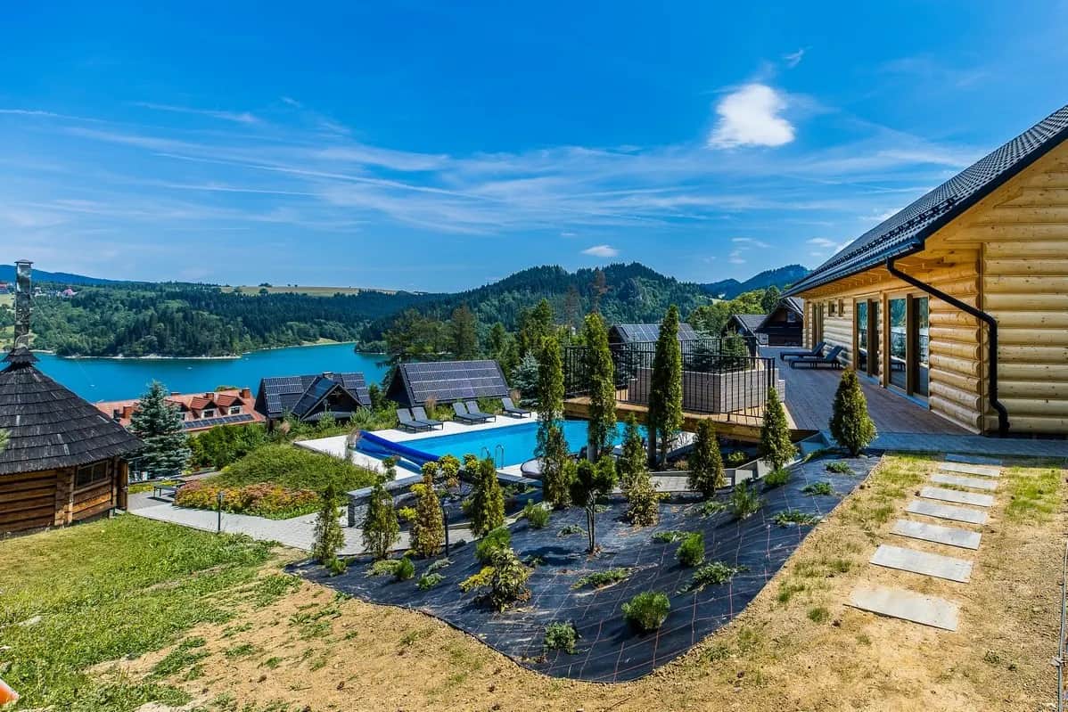 Panorama resortu Mergen z basenem, domkami i jeziorem w dolinie
